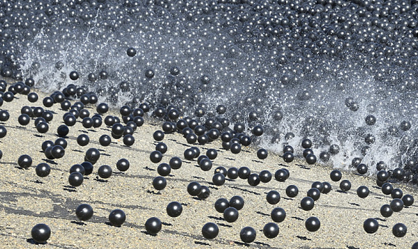 black balls hitting the water